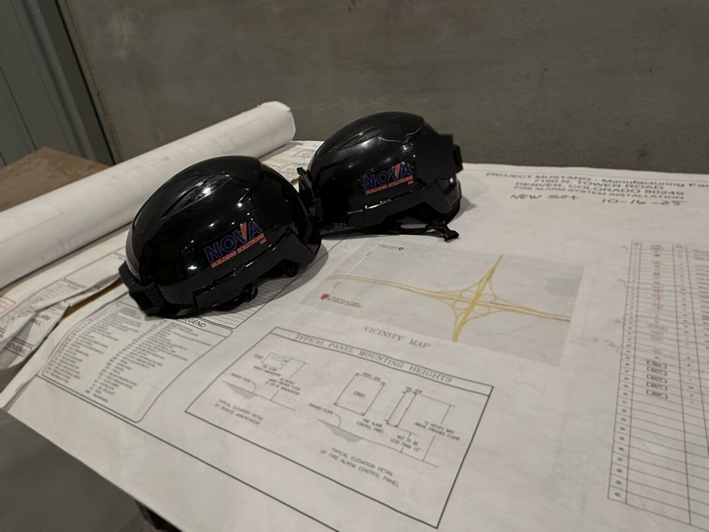 Image has a blue print and two hard hats.